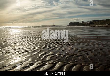 Whitby Sands, Yorkshire, Angleterre, Royaume-Uni. En regardant le long de Whitby Sand jusqu'à West Pier à Whitby, au petit matin Banque D'Images