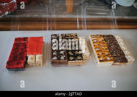 Différents morceaux de gâteaux dans des boîtes en plastique Banque D'Images