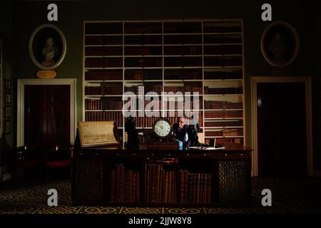 L'horologue Jonathan Betts inspecte une horloge en acajou Chippendale vers 1790, à l'intérieur de la bibliothèque de Stourhead House National Trust, dans le Wiltshire, où tous les anciens articles d'horlogerie exposés au public ont été liquidés pendant la pandémie et sont maintenant en cours de service, de blessure et de vérification, ainsi, ils peuvent à nouveau marquer et sonner en tant que chronométreurs fonctionnels et historiques. Date de la photo: Jeudi 28 juillet 2022. Banque D'Images