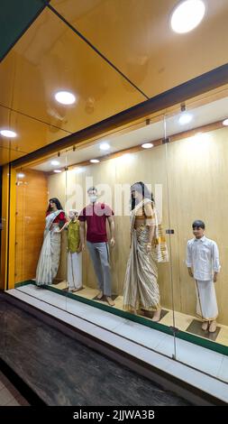 mannequins de tailles adultes et enfants, courts et grands, présentés dans une vitrine en verre devant une boutique de vêtements Banque D'Images