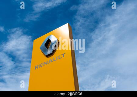 Signe du groupe français Renault avec son logo en forme de losange sur fond jaune Banque D'Images