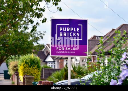 Un panneau en ligne d'agents immobiliers en vente 'Purple Bricks' à l'extérieur d'une maison de banlieue à Shepperton Surrey au Royaume-Uni Banque D'Images