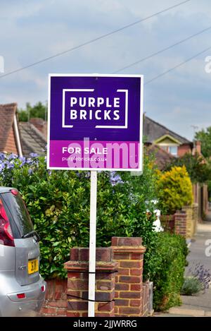 Un panneau en ligne d'agents immobiliers en vente 'Purple Bricks' à l'extérieur d'une maison de banlieue à Shepperton Surrey au Royaume-Uni Banque D'Images
