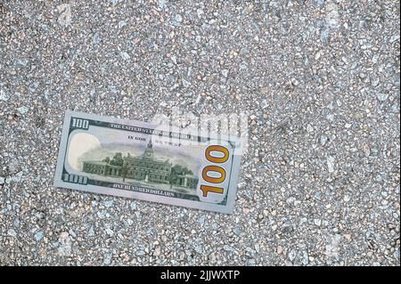 Une facture de cent dollars se trouve sur le trottoir. Argent des États-Unis. Plus grande dénomination Banque D'Images