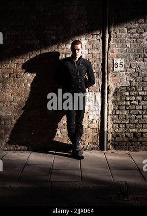 Attitude urbaine: La vie nocturne. Une attitude confiante d'un personnage de style de vie alternatif ; d'une série d'images avec le même modèle. Banque D'Images