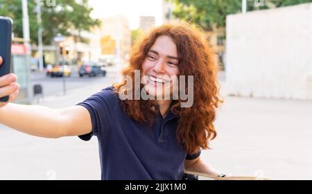 Jeune femme souriante prenant un autoportrait sur un smartphone Banque D'Images
