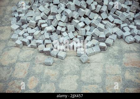 De dessus pile de briques de pierre située sur un sentier pavé sale pendant les travaux de construction Banque D'Images