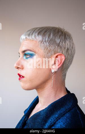 Portrait d'un jeune homme transgenre avec maquillage regardant loin Banque D'Images