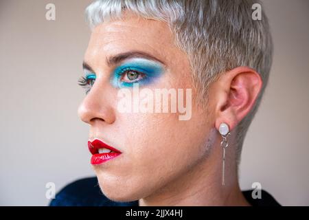 Portrait d'un jeune homme transgenre avec maquillage regardant loin Banque D'Images