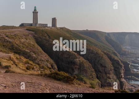 Le magnifique littoral à côté du phare Phare du Cap Frehel dans les Côtes-d'Armor, en France. Les rochers et l'herbe sur la péninsule sous le soleil Banque D'Images