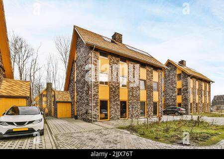 Maisons modernes en briques rustiques avec une voiture garée sur la rue pavée Banque D'Images