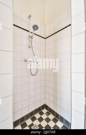 Intérieur de la salle de bains avec cabine de douche vide avec murs carrelés blancs dans l'appartement Banque D'Images