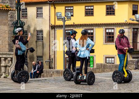 Groupe de touristes utilisant des scooters de transport personnel Segway tout en visitant le centre de Porto, une grande ville dans le nord du Portugal. Banque D'Images