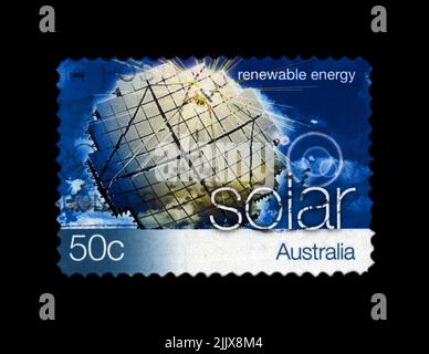 Station solaire sur ciel bleu avec nuages, énergie solaire renouvelable, vers 2004. Annulé timbre postal imprimé en Australie isolé sur backgrou noir Banque D'Images