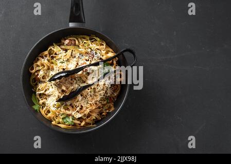 Fetuccini italien fait maison ou pâtes alfredo, également appelées Funghi Porcini cuisinées dans une poêle en fonte avec champignons et sauce à la crème Banque D'Images