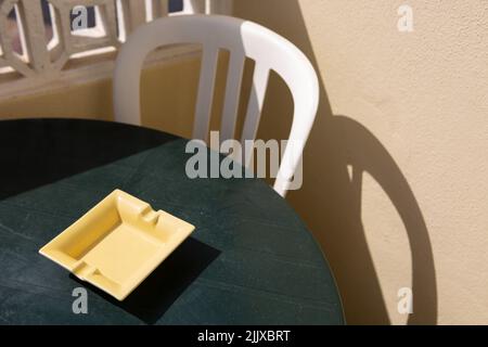Raposeira, Portugal. 17th juillet 2022. Un cendrier jaune se trouve sur un balcon d'un appartement de vacances sur une table en plastique. Crédit : Viola Lopes/dpa/Alamy Live News Banque D'Images