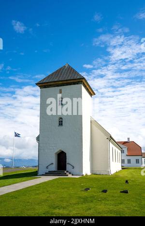 Álftanes, Islande - 1 juillet 2022 vue verticale de l'église du Bessastadir, un modeste groupe de bâtiments blancs au toit rouge qui est le r officiel Banque D'Images