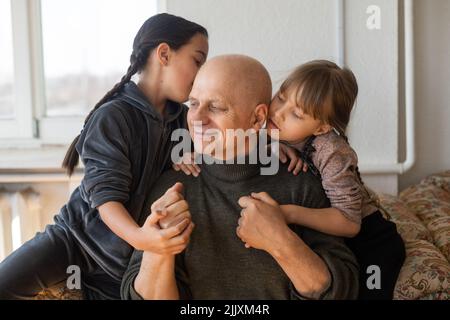 Grand-père ukrainien et deux petites-filles embrassant Banque D'Images