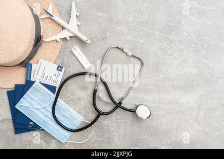 Concept de voyage et de vacances.Accessoires et articles de voyage.Jouet d'avion sur passeport avec billets d'avion et masques pour le visage.Vue de dessus de la mise à plat avec copie Banque D'Images