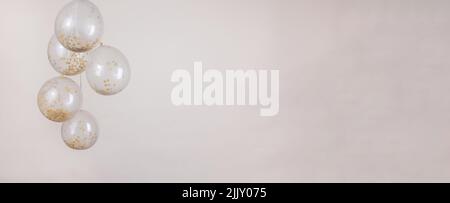 Un or monochromatique, blanc cassé et beige confetti ballons transparents sur un fond beige clair pour une bannière Banque D'Images