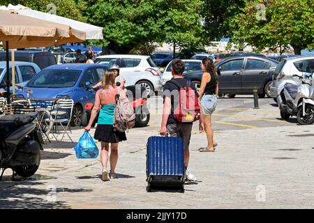 Corfou, Grèce - juin 2022 : deux jeunes avec leurs bagages se rendent au terminal de ferry de la ville de Corfou Banque D'Images