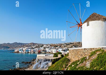 L'un des célèbres moulins à vent de Chora, île de Mykonos, Grèce. En arrière-plan, quartier pittoresque de la « petite Venise ». Banque D'Images