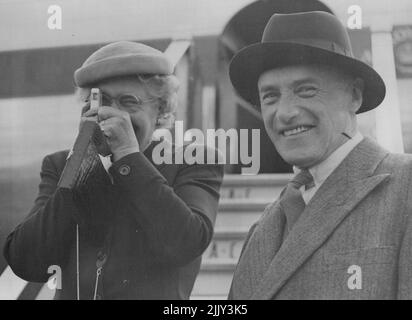 Lord and Lady Swinton Off on Commonwealth Tour -- tourner les tables sur le présent Lady Swinton photographies les photographes avec un appareil photo très miniature et avec Lord Swinton à droite, elle a quitté l'aéroport de Londres par BOAC Comet à jour (jeudi). Ils partent pour une tournée de semaines de vue des pays du Commonwealth au cours de laquelle Lord Swinton, qui est le secrétaire d'État pour les relations du Commonwealth, prendra des contacts personnels entre les ministres de l'Australie, de la Nouvelle-Zélande, du Pakistan, de l'Inde et de Ceylan. 24 septembre 1953. (Photo de Reuterphoto). Banque D'Images