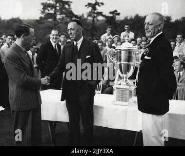 Après le Putting Duel - John Jackson Président de l'Association américaine de golf, présente la Walker Cup au capitaine Francis Ouimet de l'équipe américaine après la victoire ici sur les envahisseurs britanniques. Le Dr William Tweddell, capitaine du contingent de golf britannique, est à gauche, se serrant la main avec Ouimet. 03 septembre 1936. (Photo par photo de presse associée). Banque D'Images