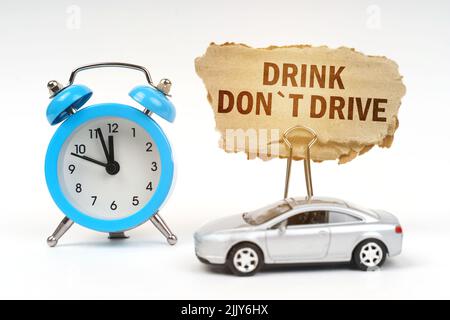 Concept de transport. Sur une surface blanche il y a un réveil bleu, une voiture et un panneau avec l'inscription - Drink Do Drive Banque D'Images