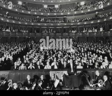 Metropolitan brille le 70th anniversaire -- Voici une vue générale de l'intérieur de Metropolitan Opera House ici ce soir alors que le public attend le deuxième rideau d'action de Gounod 'Faust'. L'ouverture a été le 70th anniversaire du célèbre centre de musique. Le chef d'orchestre Pierre Monteux, au centre droit, en premier plan, lève le bâton pour faire remonter le rideau. 16 novembre 1953. (Photo par AP Wirephoto). Banque D'Images