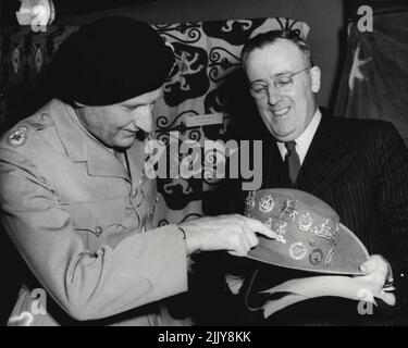 Le personnel général impérial a présenté à M. John A. Beagley, haut-commissaire pour l'Australie, le chapeau qui lui a été donné par la division australienne 9th dans le désert occidental 14 août 1942, à la maison australienne, Londres, cet après-midi 21 août. Le chapeau qui a été donné au vicomte Montgomery du général australien, Sir Lesile Morshead, parce qu'il ne pouvait pas tenir le soleil du Bavk de son cou, est décoré avec les insignes des différentes unités visitées par Lord Montgomery. Il sera envoyé au National War Memorial Museum de Canberra. 15 septembre 1947. (Photo par photo de presse associée). Banque D'Images