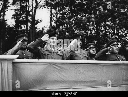 Le maréchal Montgomery visite le maréchal Rokossovsky - le maréchal Montgomery prend ses salutes comme un régiment de cosaques passe. Avec son maréchal Rokossovsky et des officiers d'état-major russes et britanniques. Photo prise sur 10 mai lorsque le maréchal Montgomery a visité le maréchal Rokossovsky à son siège social. À son arrivée, il prit le salut comme régiment de passé de la rode des cosaques, criant leur cri de bataille. Plus tard, il a déjeuné avec le maréchal soviétique, et a été amusé par des hommes et des femmes soldats russes, dans des chants et des danses folkloriques russes. 13 mai 1945. (Photo par British Official Photograph). Banque D'Images