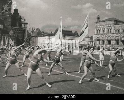 La XXIII Journée internationale de la Jeunesse à Moscou -- les culturistes de la Société sportive 'Burevestnik' (Storm-Petrel) faisant des exercices gymnastiques avec des cerceaux, en passant par la tribune sur la place Rouge. À 12 septembre 1937, les jeunes de la capitale soviétique ont célébré triomphalement la XXIII Journée internationale de la jeunesse. Un combat d'un million de jeunes patriotes, d'une génération de jeunes bâtisseurs libres de socialisme, pleins d'optimisme et sûrs de morrow, ont démontré leur force et leur pouvoir, leur dévouement au parti de Lénine-Staline et au gouvernement soviétique. 1 septembre 1937. (Photo de Soyuzphoto). Banque D'Images