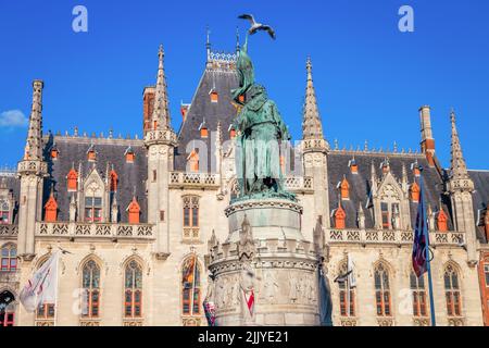 Pigeon survolant la place du marché de Bruges, architecture flamande Banque D'Images