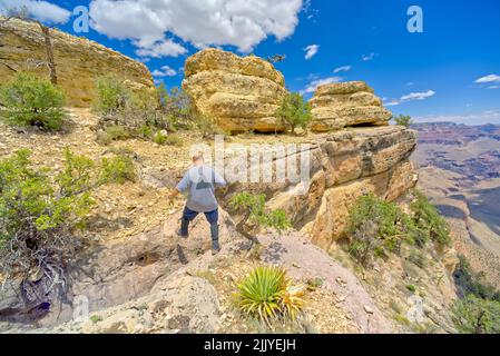 Un randonneur sautant sur un crevassé le long d'une falaise à l'ouest de Twin Views surplombe le Grand Canyon Arizona. Banque D'Images