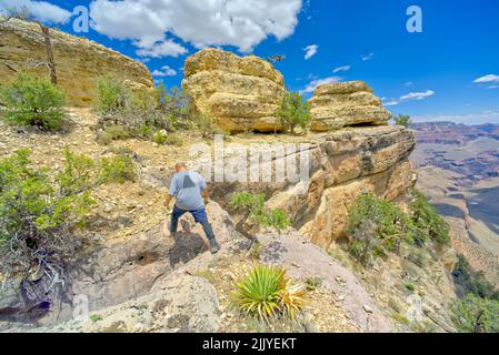 Un randonneur sautant sur un crevassé le long d'une falaise à l'ouest de Twin Views surplombe le Grand Canyon Arizona. Banque D'Images