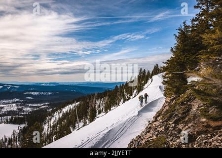 Deux skieurs se bousculent en montant tout en traversant le parc national de Crater Lake Banque D'Images