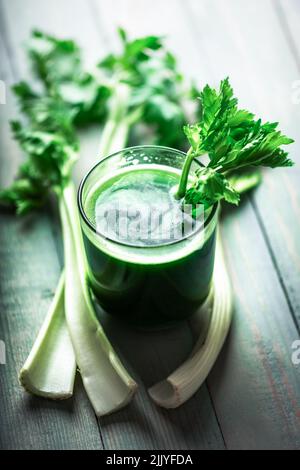 Jus de céleri vert frais dans le verre sur fond de bois. Concept de nourriture végétarienne saine Banque D'Images