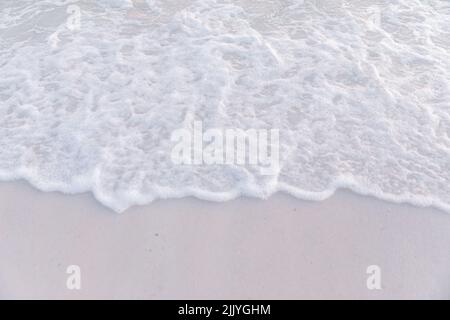 Vagues s'écrasant sur la plage au coucher du soleil Banque D'Images