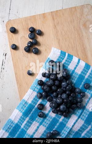 Vue de dessus des bleuets sur une planche à découper en bois. Photo verticale Banque D'Images