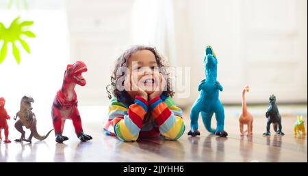 Enfant jouant avec des dinosaures colorés. Jouets éducatifs pour enfants. Petit garçon apprenant fossiles et reptiles. Les enfants jouent avec des jouets de dinosaure. Banque D'Images