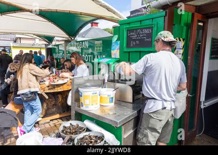 Clients achetant des fruits de mer frais et des mollusques à Oban port, moules, crabe, homards tous vendus et moules cuits à l'ail, Oban, Highlands, Écosse, Banque D'Images