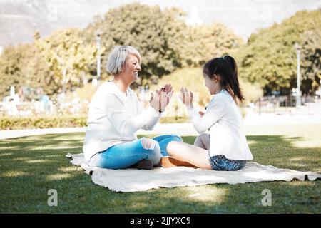 C'est toujours amusant et jeux quand theyre ensemble. Une petite fille ayant plaisir avec sa grand-mère dehors. Banque D'Images