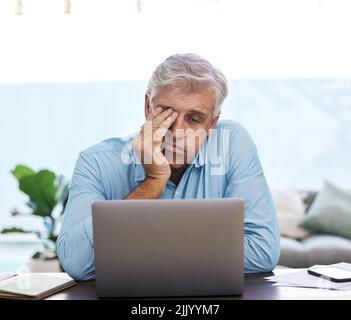 Je ne peux pas continuer. Un homme mûr assis seul et se sentant stressé tout en utilisant son ordinateur portable pour travailler de la maison. Banque D'Images