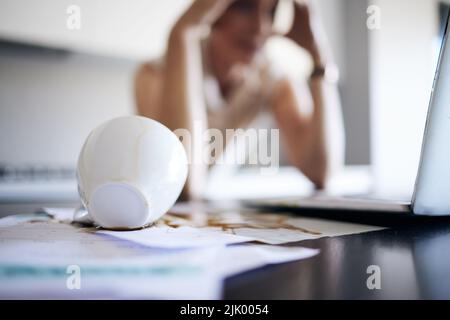 Tout mon dur travail a disparu. Une femme méconnaissable se sentait stressée après avoir versé du café sur ses papiers dans la cuisine à la maison. Banque D'Images