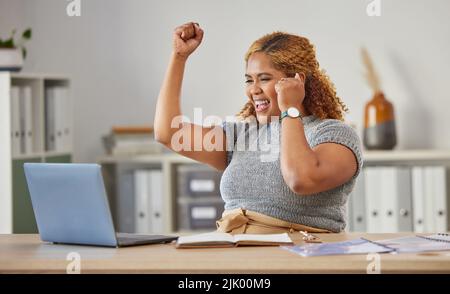 Une femme d'affaires enthousiaste, heureuse et heureuse qui se réjouit de la réussite de son travail sur un ordinateur portable dans son bureau. Jeune entrepreneur, indépendant ou distant Banque D'Images