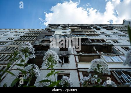 Des fleurs ont été vues en pleine croissance devant un immeuble résidentiel très endommagé à Saltivka. Le district de Saltivka était autrefois l'un des quartiers les plus densément peuplés de la ville de Kharkiv s'est transformé en ruines et en ruines, alors que le district continue de subir des bombardements intenses de l'armée russe. Banque D'Images