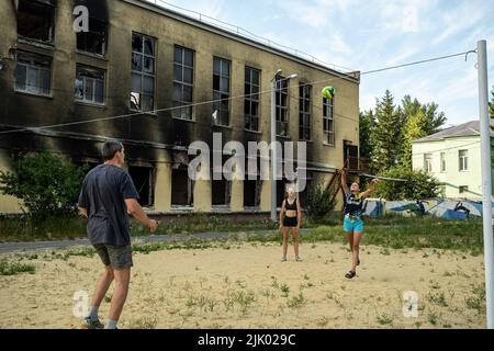 Kharkiv, Ukraine. 08th juillet 2022. Une famille joue au volley-ball à côté des ruines d'une école à Kharkiv. Kharkiv est la deuxième plus grande ville d'Ukraine, a été l'une des principales cibles stratégiques de l'invasion russe, et depuis le début de la guerre, la ville a subi de multiples attaques de missiles, comme les responsables ont désigné la ville comme la « ville Hero d'Ukraine ». (Photo par Alex Chan TSZ Yuk/SOPA Images/Sipa USA) crédit: SIPA USA/Alay Live News Banque D'Images