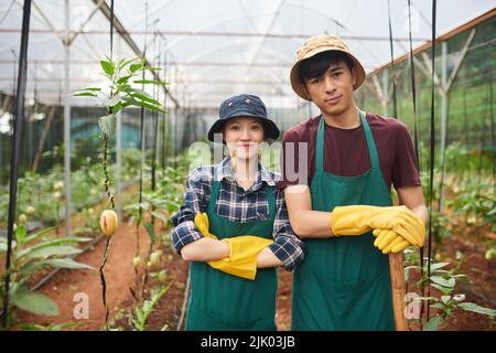 Portrait de travailleurs agricoles souriants en tabliers et gants Banque D'Images