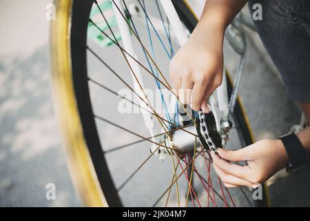 Image rapprochée d'une femme qui fixe une chaîne de vélo Banque D'Images